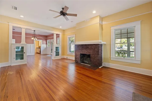 a view of empty room with wooden floor and fireplace