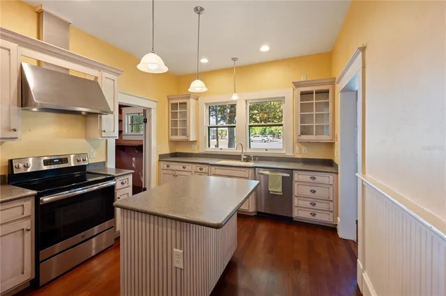 a kitchen with stainless steel appliances granite countertop a sink a stove and a refrigerator