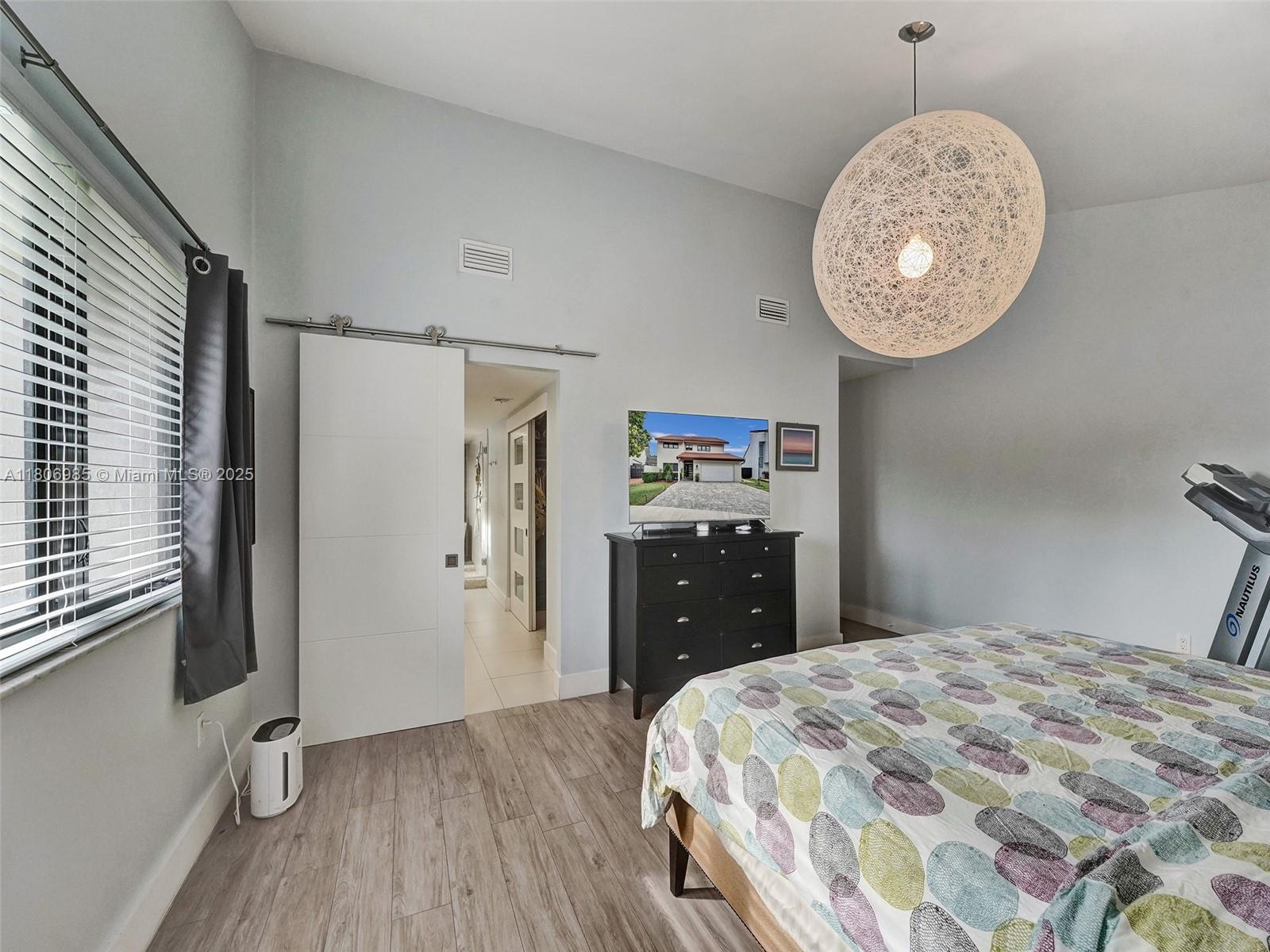 3638 Southwest 57th Avenue Miami, FL 33155 - Photo 22 of 43 a bedroom with a bed and a chandelier