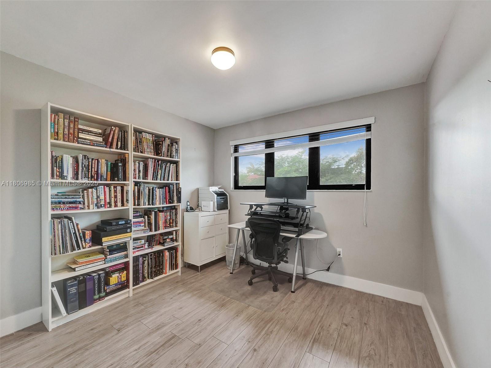 3638 Southwest 57th Avenue Miami, FL 33155 - Photo 26 of 43 a view of a workspace with furniture and a bookshelf