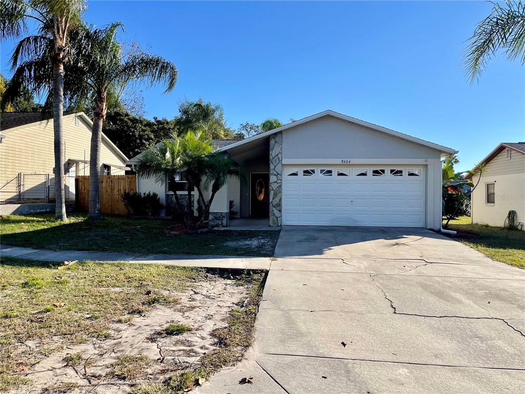 8604 Schrader Boulevard Port Richey, FL 34668 - Photo 1 of 1 a front view of a house with a yard and garage
