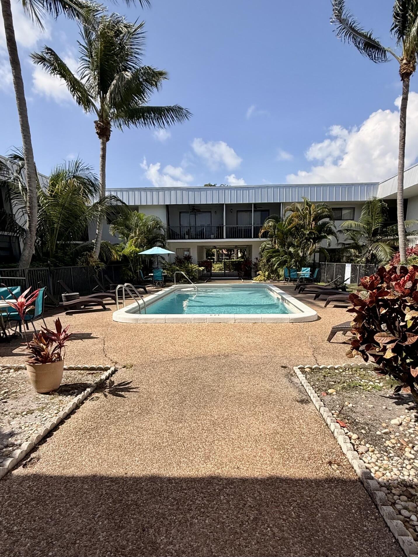 875 Northwest 13th Street, Unit 405 Boca Raton, FL 33486 - Photo 3 of 16 a view of a swimming pool with a yard