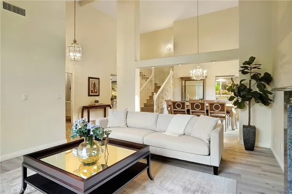 a living room with furniture large window and potted plants