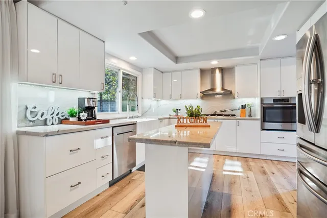 a dining room with stainless steel appliances granite countertop furniture a chandelier and wooden floor