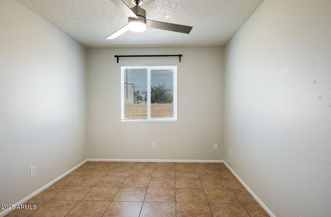 1861 N Spring Mesa, AZ 85203 - Photo 13 of 29 an empty room with a ceiling fan and a window