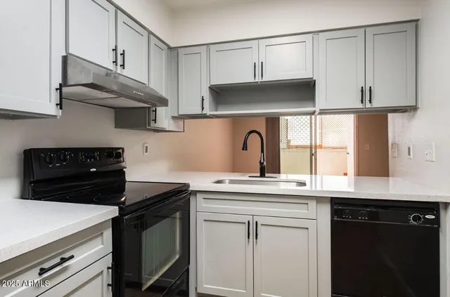 a kitchen with stainless steel appliances granite countertop a sink a stove and cabinets