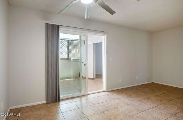an empty room with a window and a fan