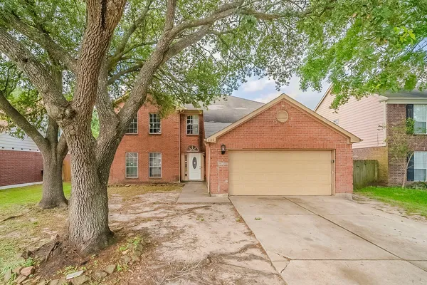 a view of a house with a tree in front of it