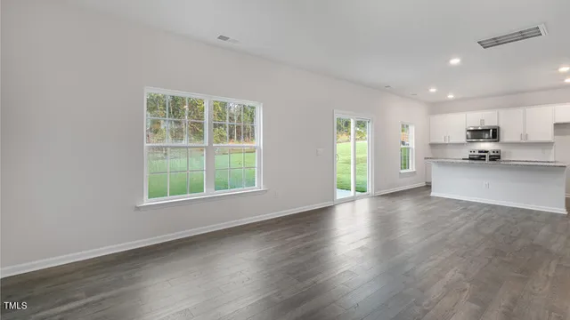 a view of a kitchen and window with wooden floor