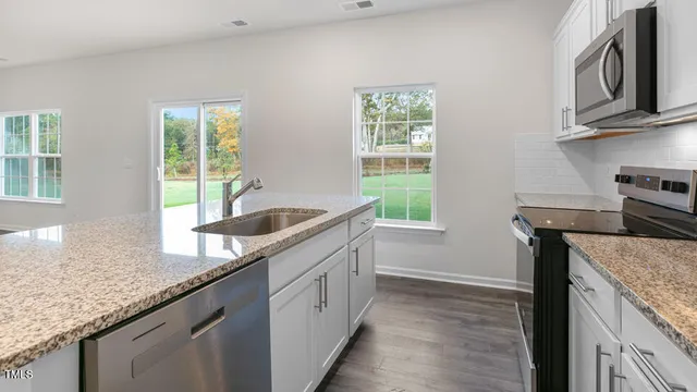 a kitchen with granite countertop a sink and a stove