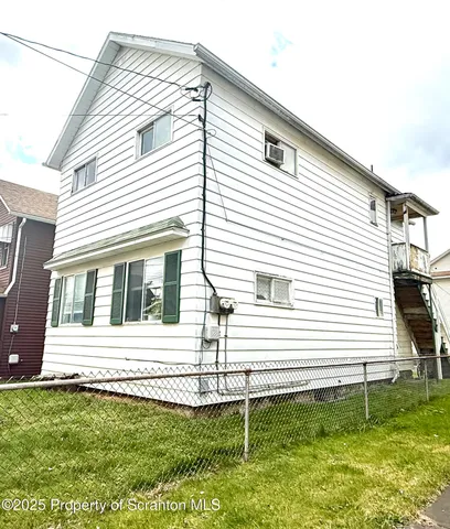 a view of a white house with a yard and sitting area