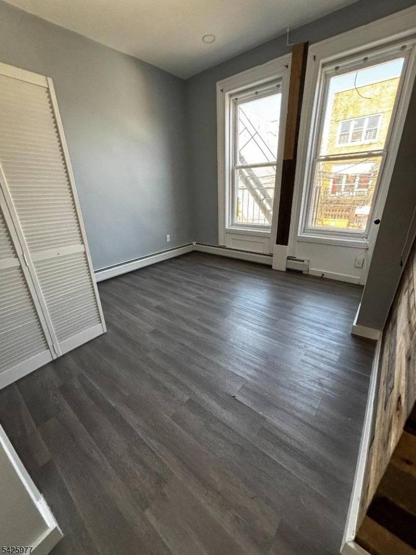 48 Market Street Paterson, NJ 07505 - Photo 6 of 8 an empty room with wooden floor and windows