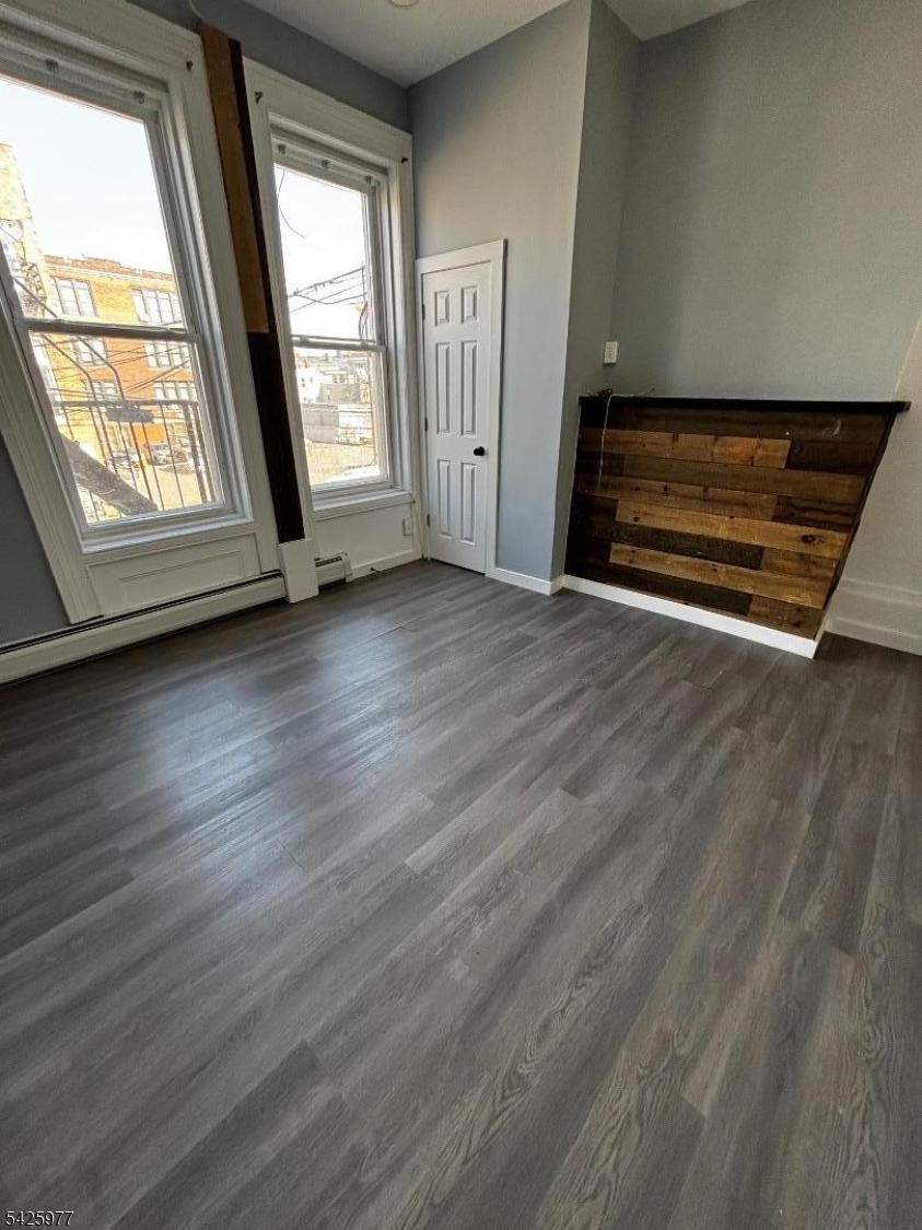 48 Market Street Paterson, NJ 07505 - Photo 7 of 8 an empty room with wooden floor and windows