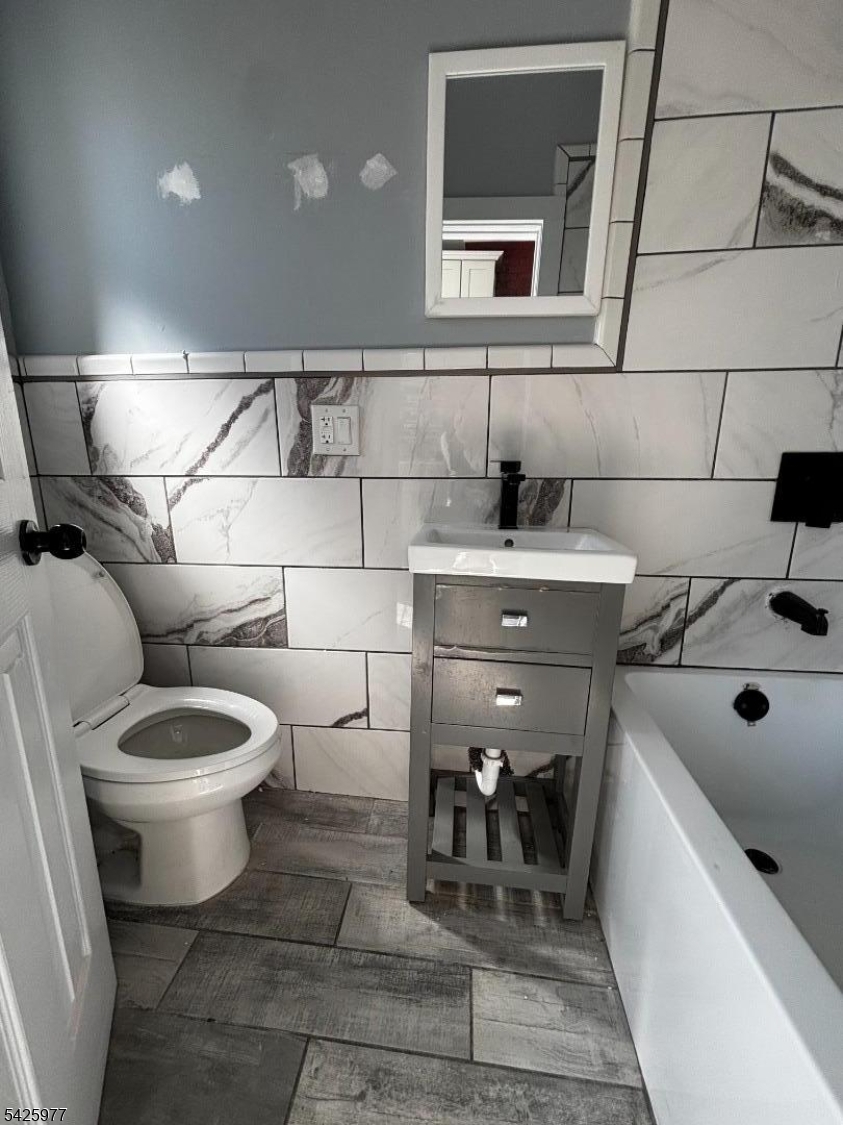 48 Market Street Paterson, NJ 07505 - Photo 8 of 8 a bathroom with a toilet sink and mirror