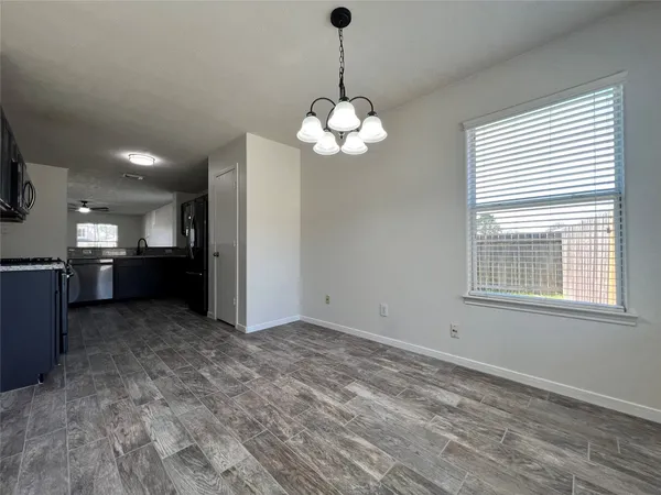 a view of a kitchen with a stove cabinets a kitchen wooden floor and a chandelier