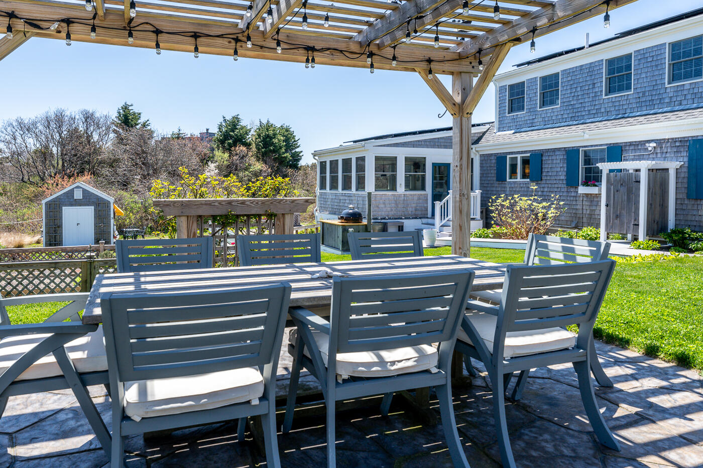 16 Bay View Road Truro, MA 02666 - Photo 47 of 57 a view of a patio with a table chairs and a backyard