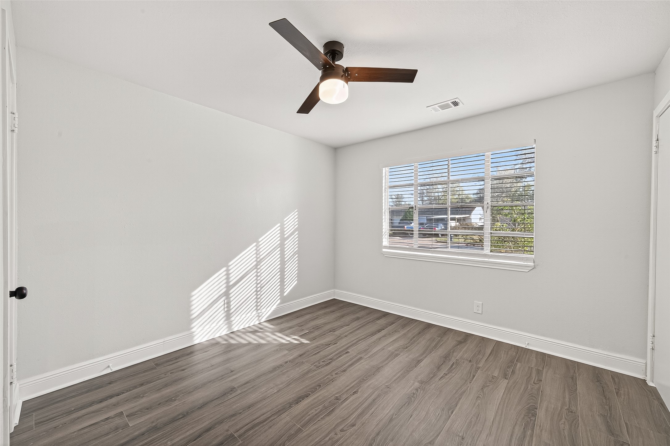 4729 Paradise Lane Houston, TX 77048 - Photo 12 of 43 a view of an empty room with wooden floor and a window