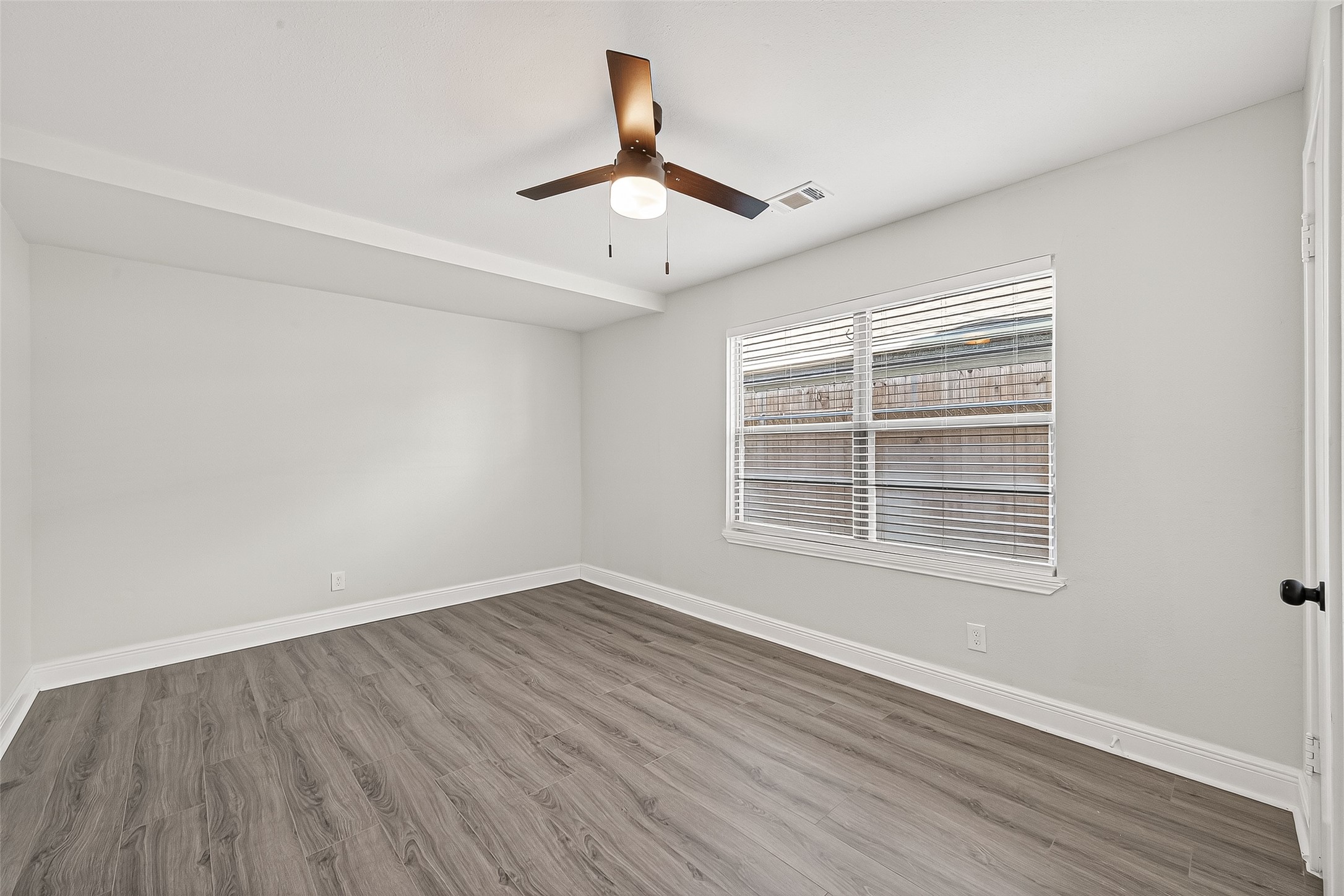 4729 Paradise Lane Houston, TX 77048 - Photo 14 of 43 a view of an empty room with wooden floor and a window
