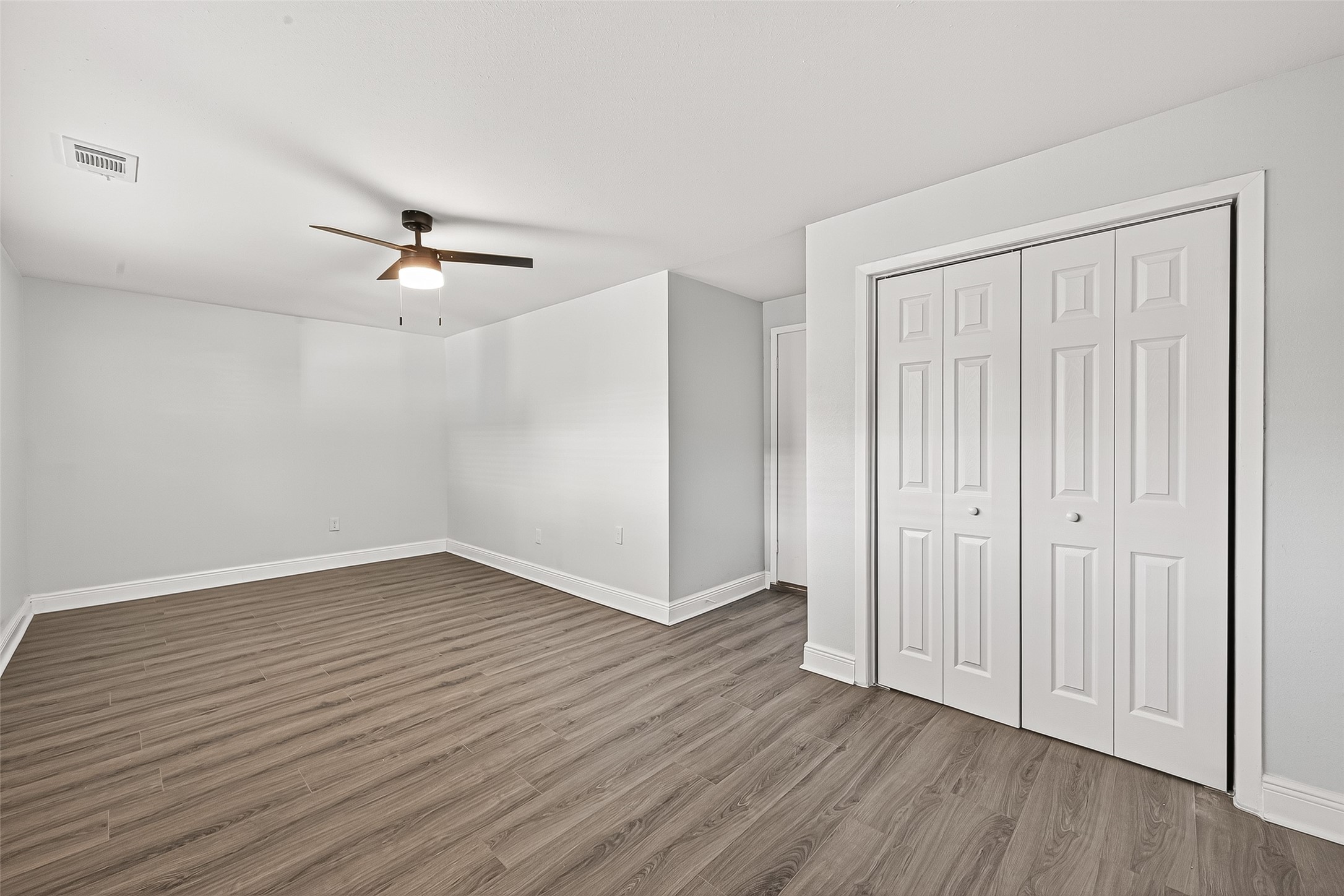 4729 Paradise Lane Houston, TX 77048 - Photo 23 of 43 an empty room with wooden floor chandelier fan and windows