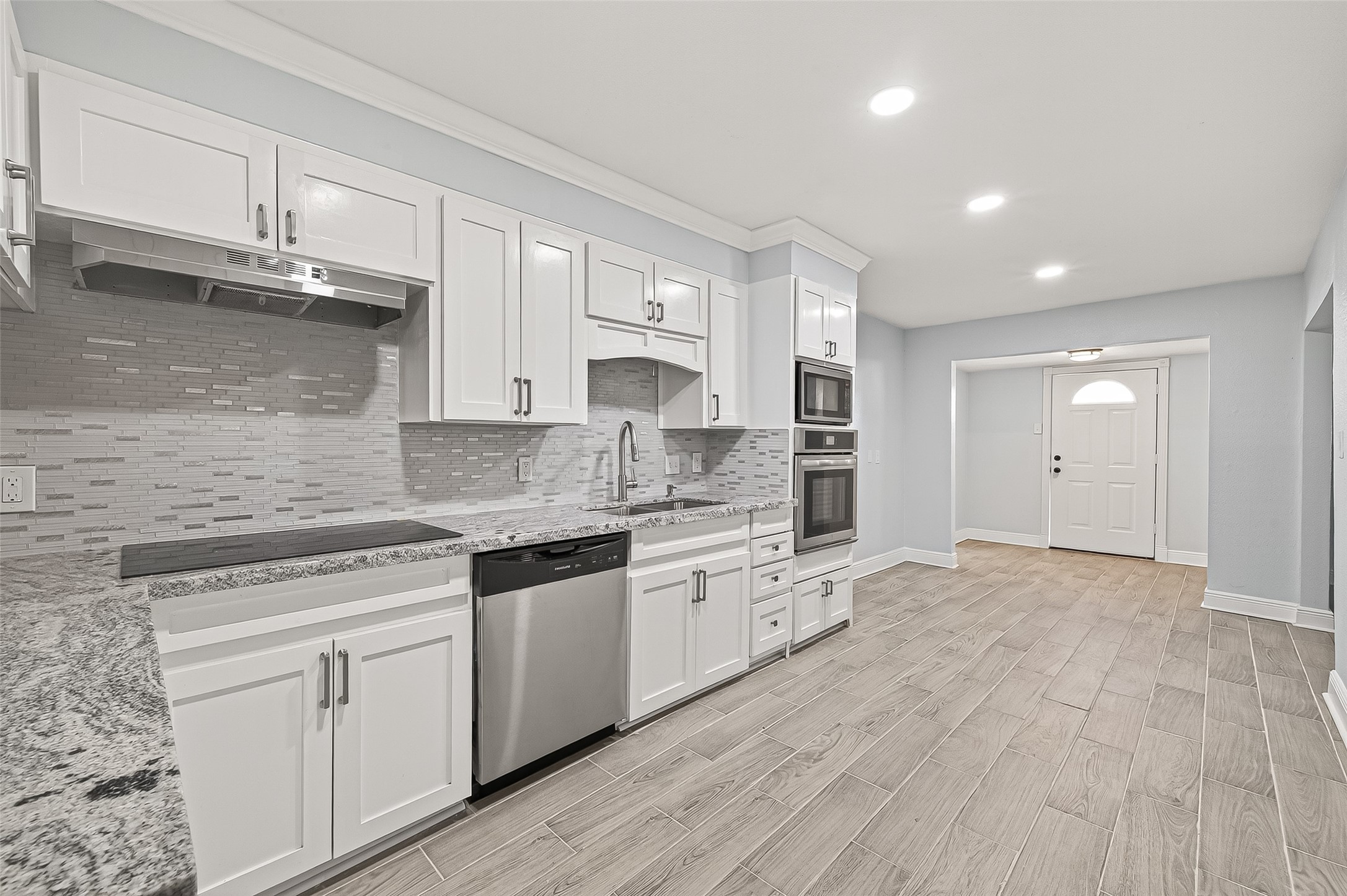 4729 Paradise Lane Houston, TX 77048 - Photo 30 of 43 a large kitchen with granite countertop a stove top oven a sink and white cabinets