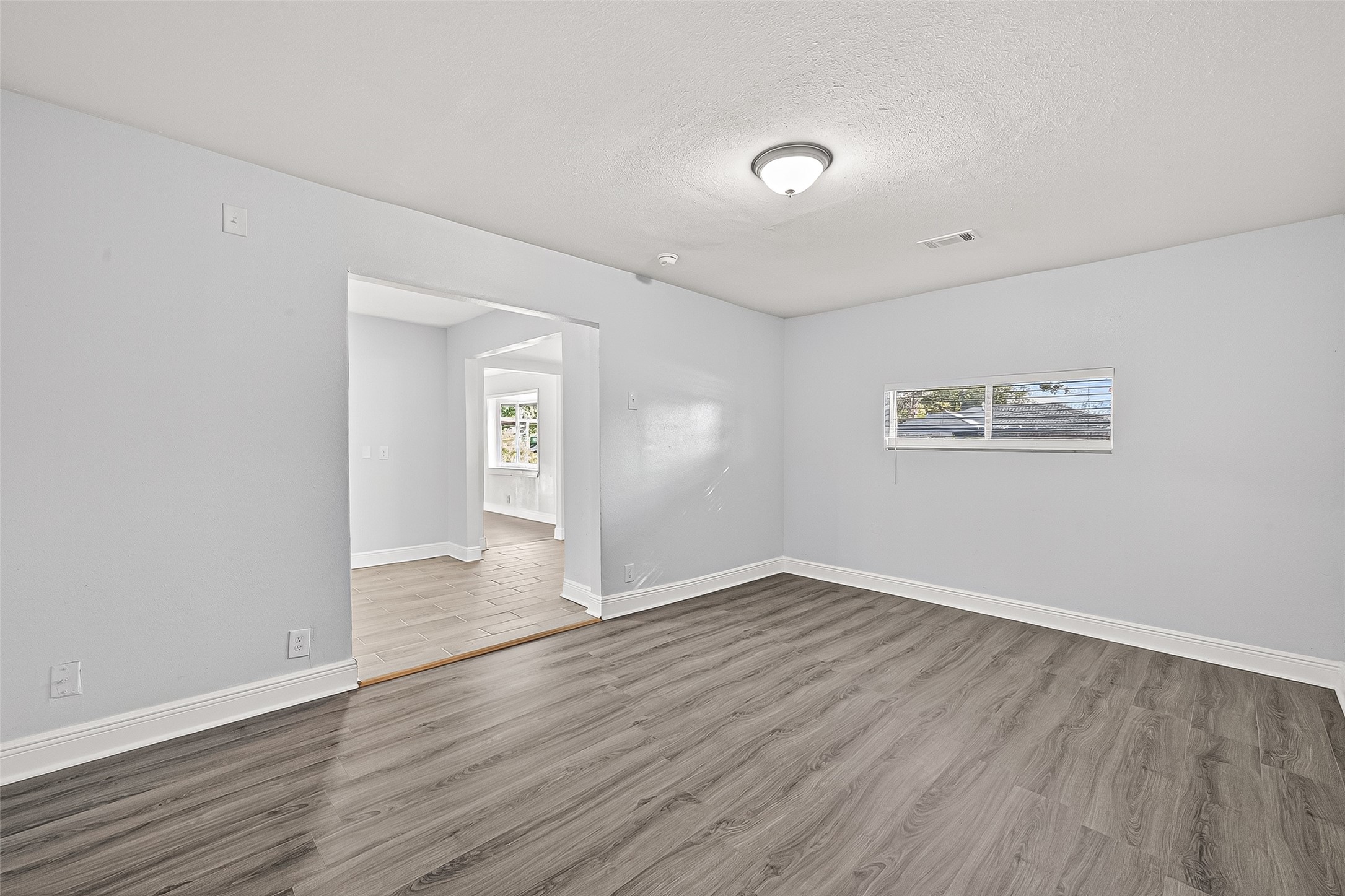 4729 Paradise Lane Houston, TX 77048 - Photo 5 of 43 an empty room with wooden floor and windows
