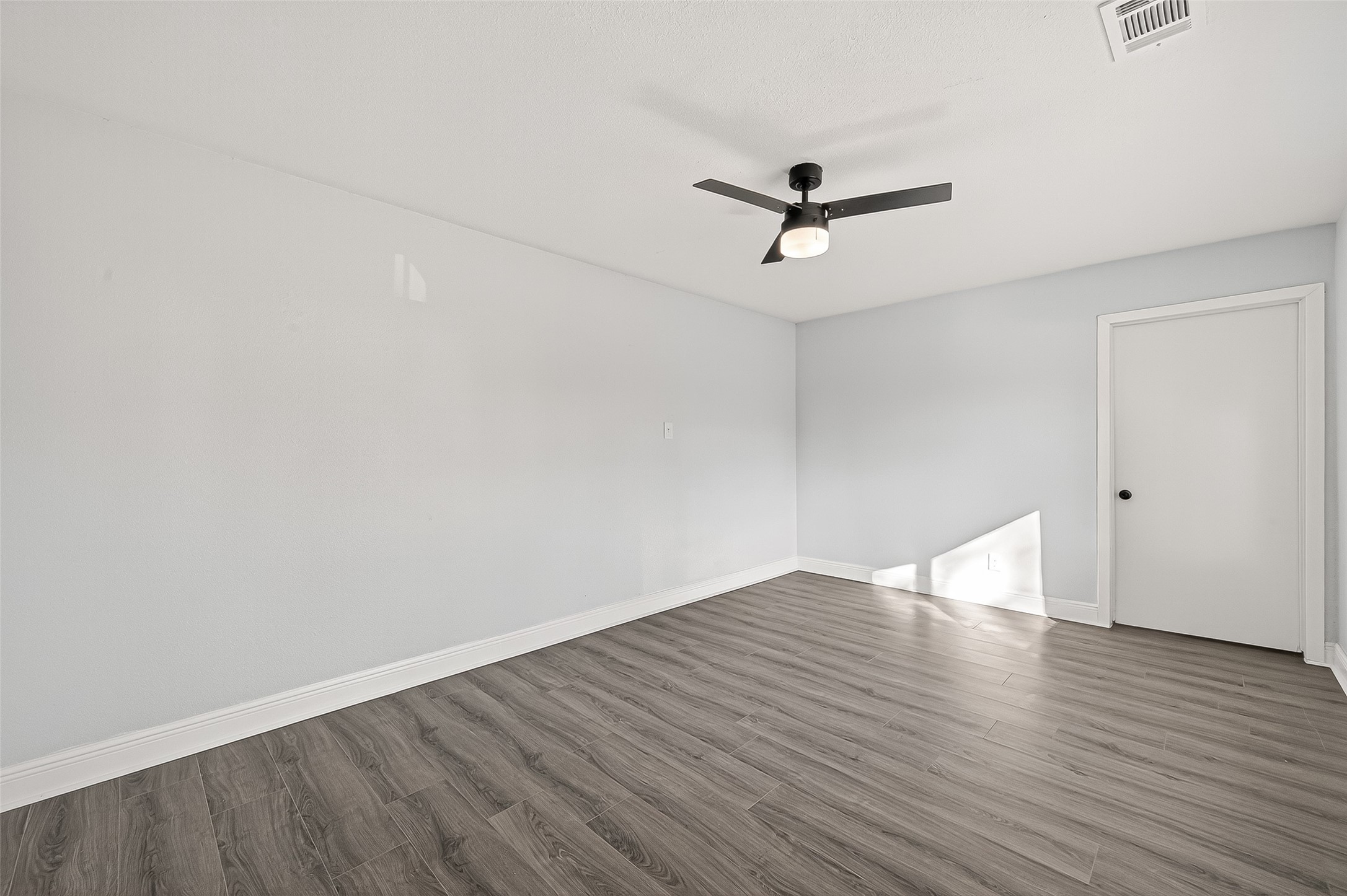 4729 Paradise Lane Houston, TX 77048 - Photo 10 of 43 an empty room with wooden floor and ceiling fan