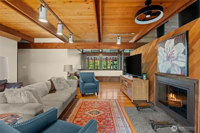 a view of a patio with couches and table and chairs with wooden floor and fence