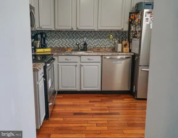 a kitchen with stainless steel appliances granite countertop a refrigerator and a stove