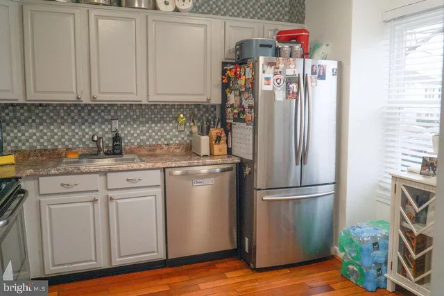 a kitchen with stainless steel appliances granite countertop a refrigerator and a sink