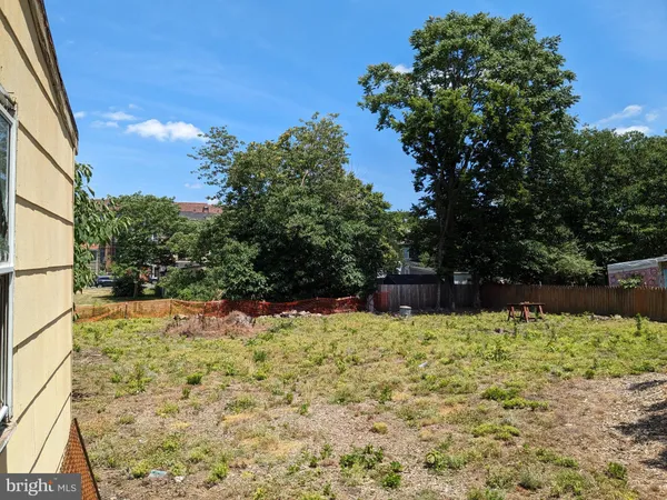 a view of flower garden with wooden fence