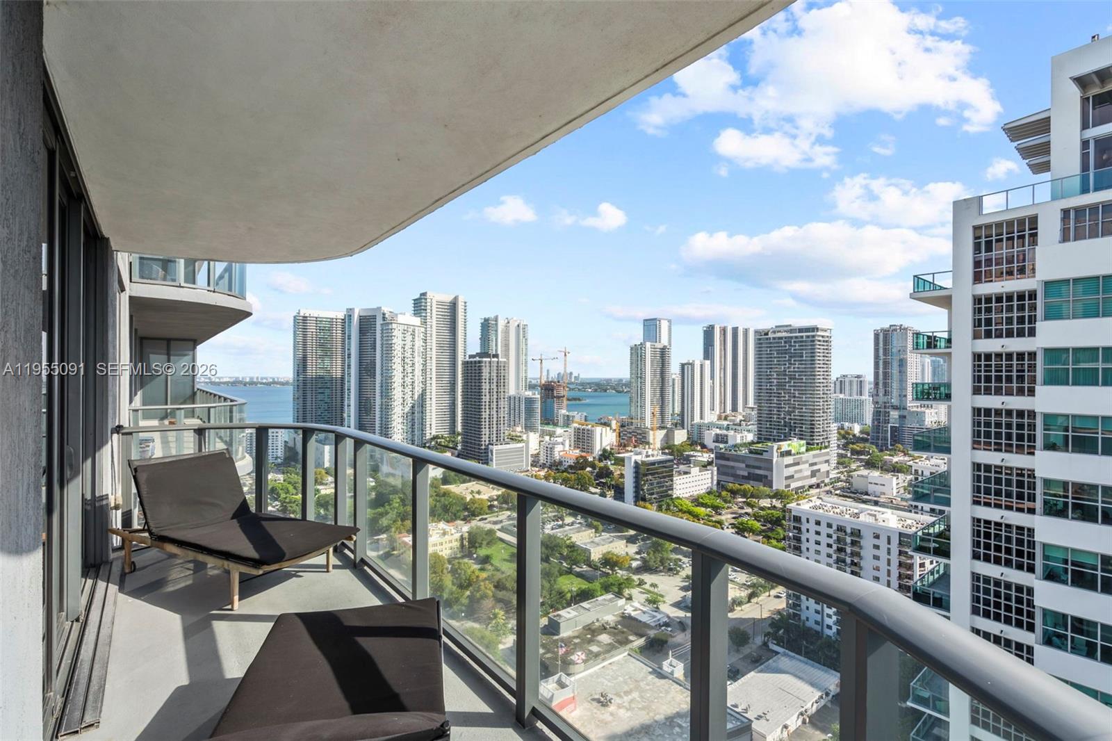 121 Northeast 34th Street, Unit 3001 Miami, FL 33137 - Photo 13 of 13 a view of a balcony with wooden chairs