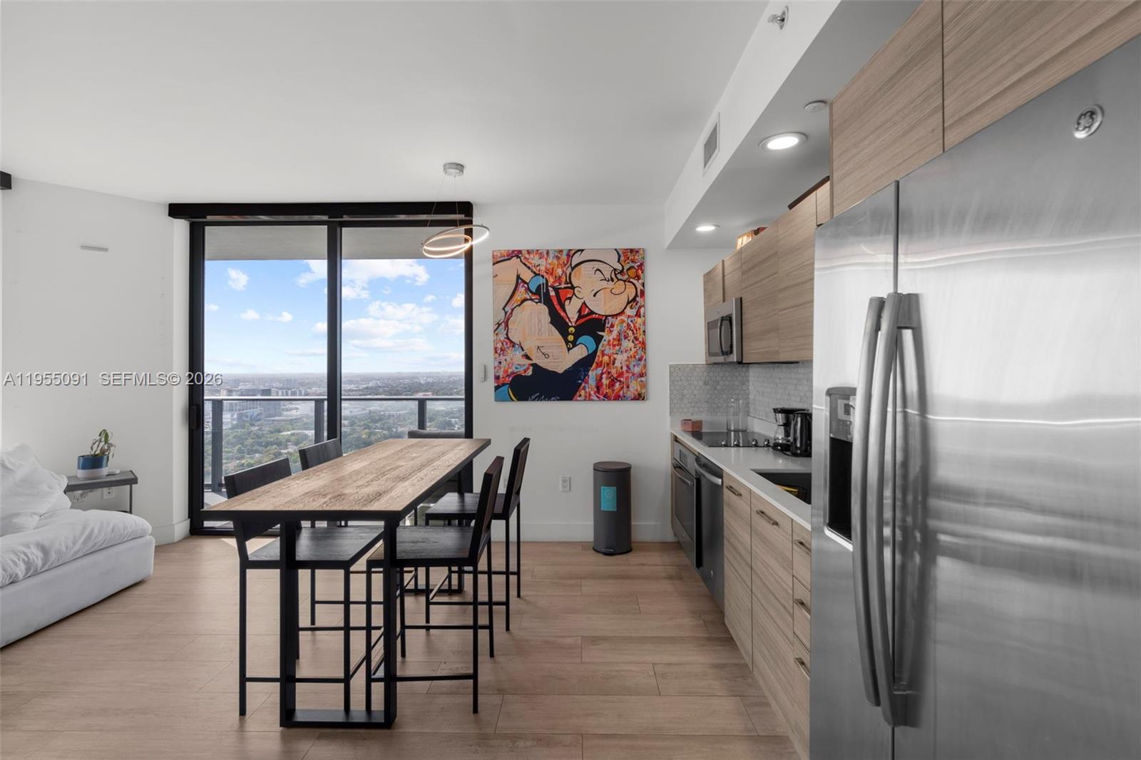 121 Northeast 34th Street, Unit 3001 Miami, FL 33137 - Photo 3 of 13 a kitchen with stainless steel appliances granite countertop a stove a refrigerator and a dining table