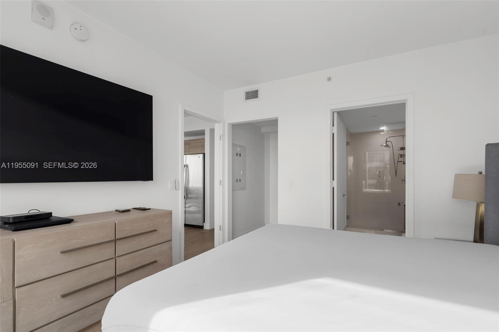 121 Northeast 34th Street, Unit 3001 Miami, FL 33137 - Photo 6 of 13 a bedroom with a bed and a flat screen tv in it