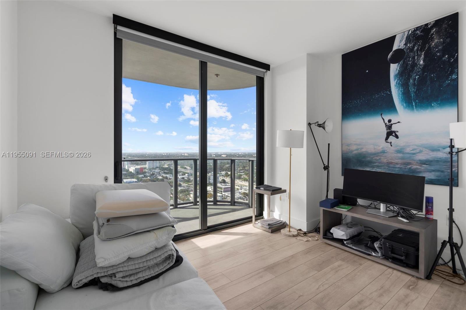 121 Northeast 34th Street, Unit 3001 Miami, FL 33137 - Photo 8 of 13 a bedroom with furniture and a floor to ceiling window
