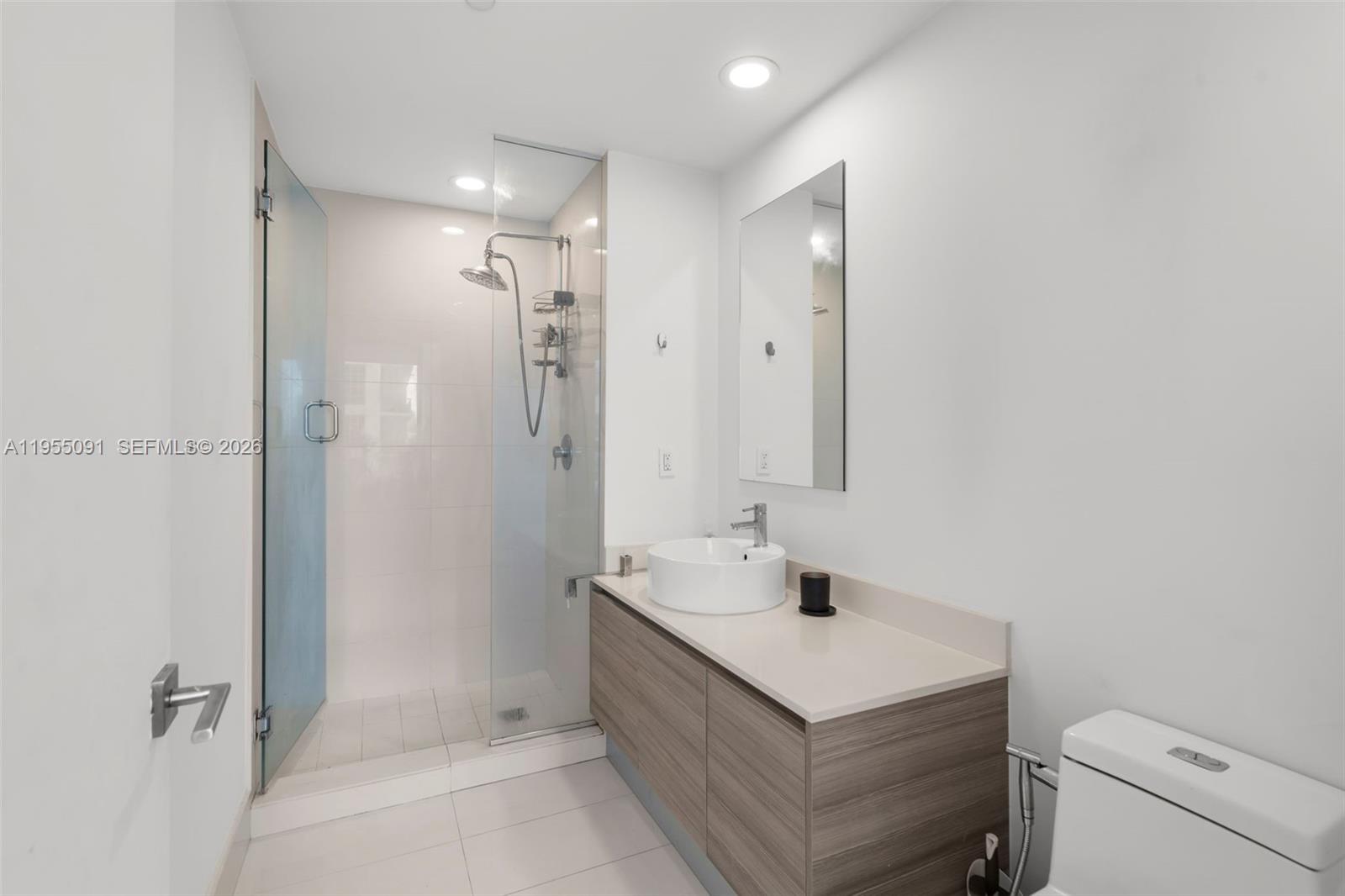 121 Northeast 34th Street, Unit 3001 Miami, FL 33137 - Photo 9 of 13 a bathroom with a sink a toilet and shower