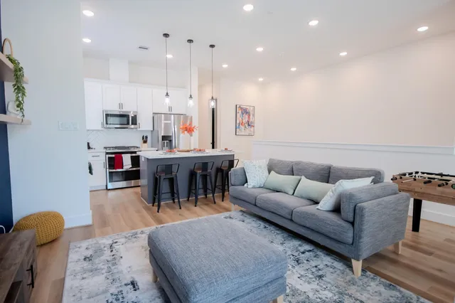 a living room with furniture kitchen view and a dining table
