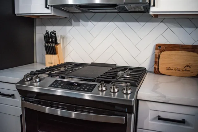a stove top oven sitting inside of a kitchen
