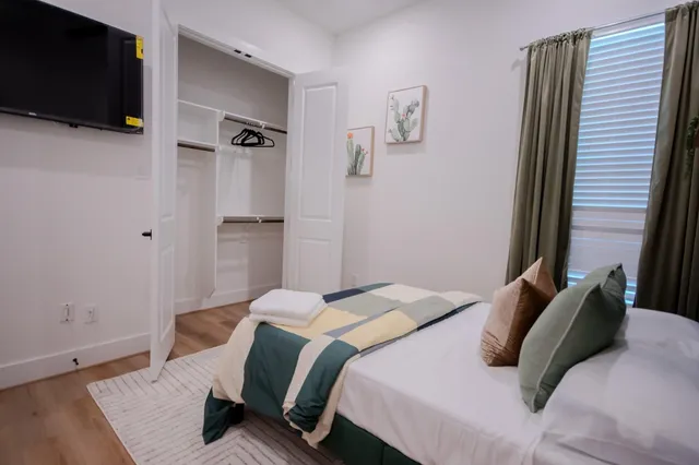 a bedroom with a bed and a flat screen tv