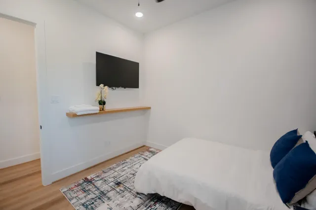 a bedroom with a bed and a flat screen tv