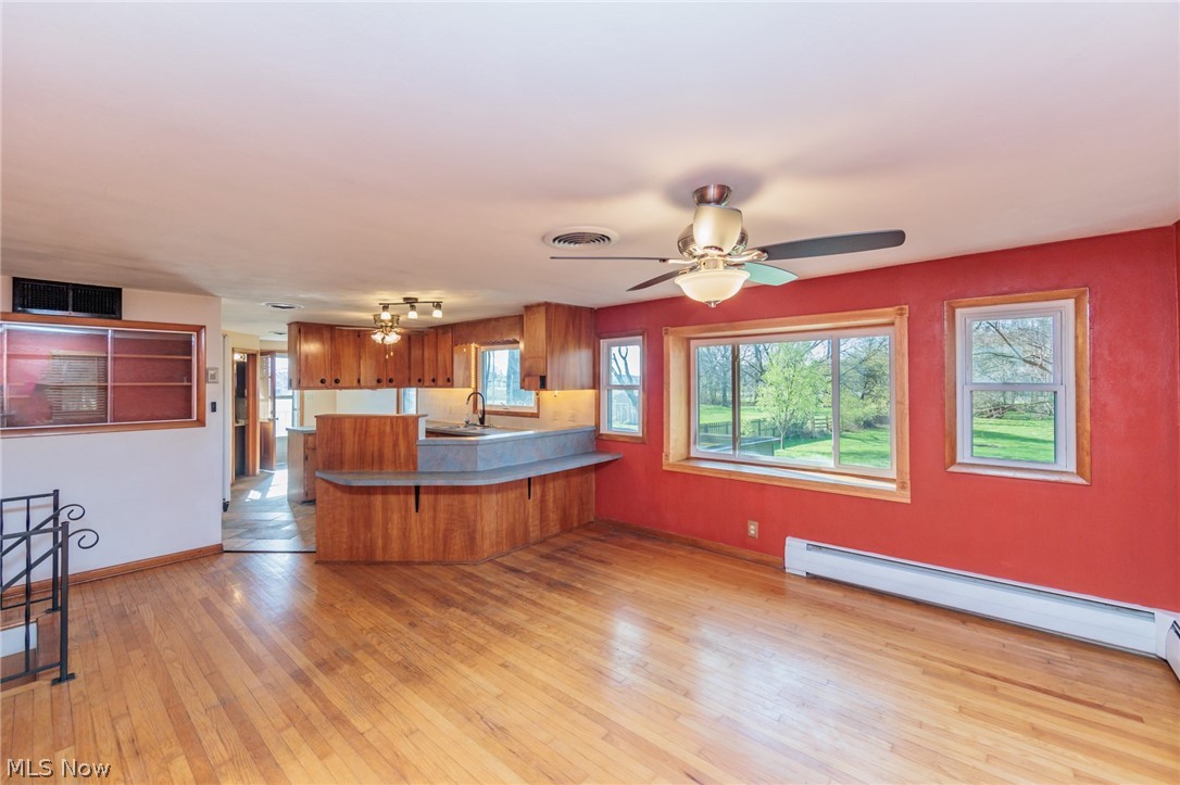 38565 Sugar Ridge Road North Ridgeville, OH 44039 - Photo 13 of 49 Kitchen featuring ceiling fan, sink, light hardwood / wood-style floors, kitchen peninsula, and baseboard heating