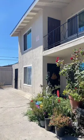 a patio with table and chairs and potted plants