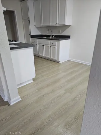 a kitchen with granite countertop white cabinets and sink