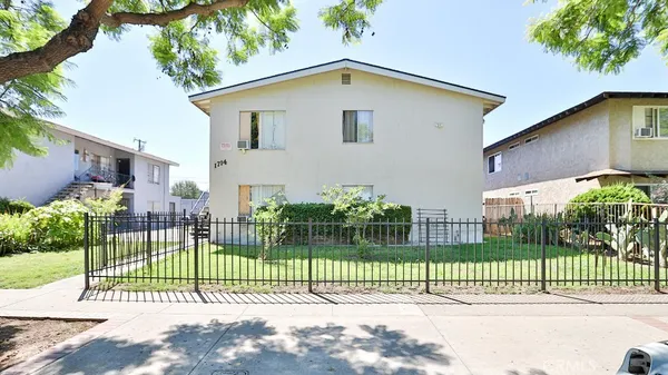 a view of a house with a fence and a garden
