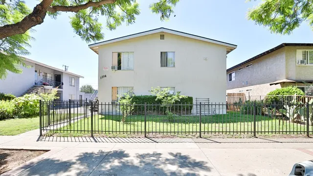 a view of a house with a fence and a garden