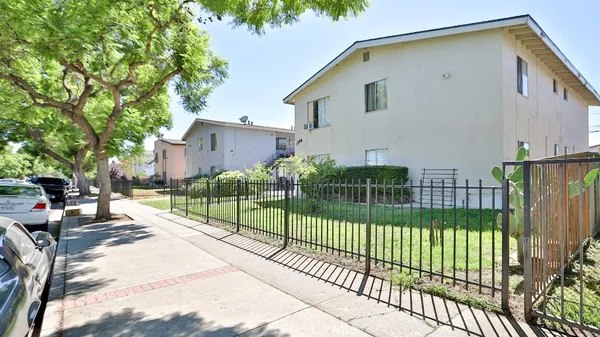 a view of a street in front of a house with a large windows