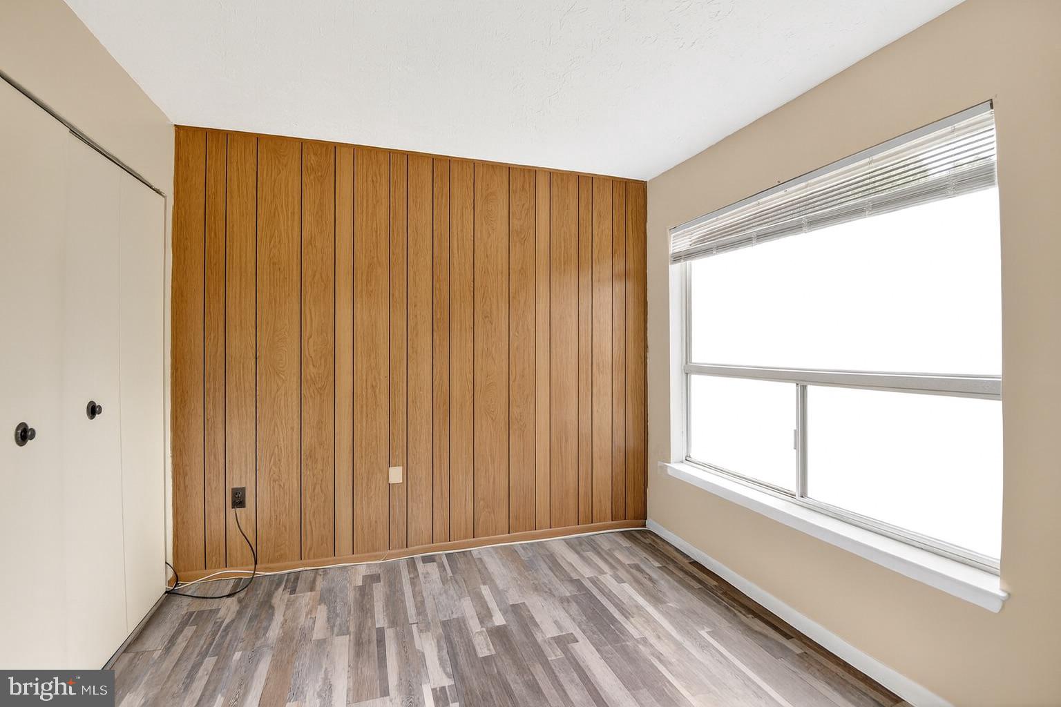 8007 Mandan Road, Unit 203 Greenbelt, MD 20770 - Photo 11 of 25 a view of an empty room with a window and hardwood floor