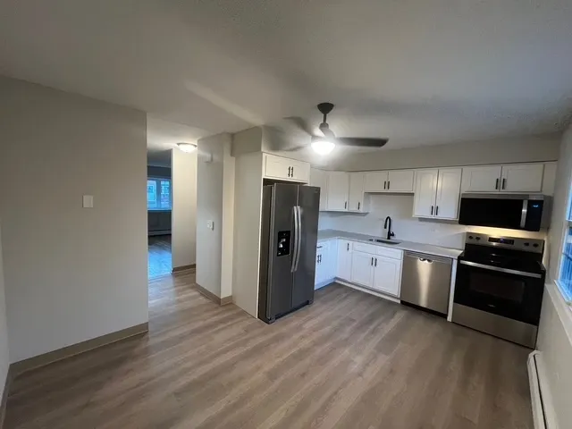 a kitchen with stainless steel appliances granite countertop a refrigerator and a stove top oven