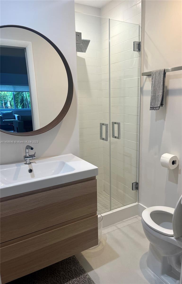 337 Southwest 23rd Road, Unit 1 Miami, FL 33129 - Photo 11 of 31 a bathroom with a granite countertop sink toilet and shower