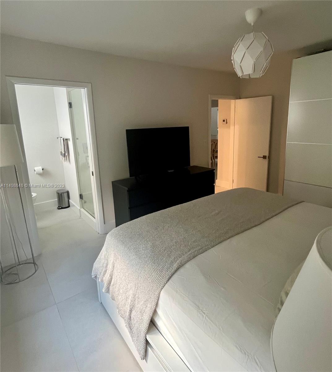 337 Southwest 23rd Road, Unit 1 Miami, FL 33129 - Photo 13 of 31 a bedroom with a bed and a chandelier