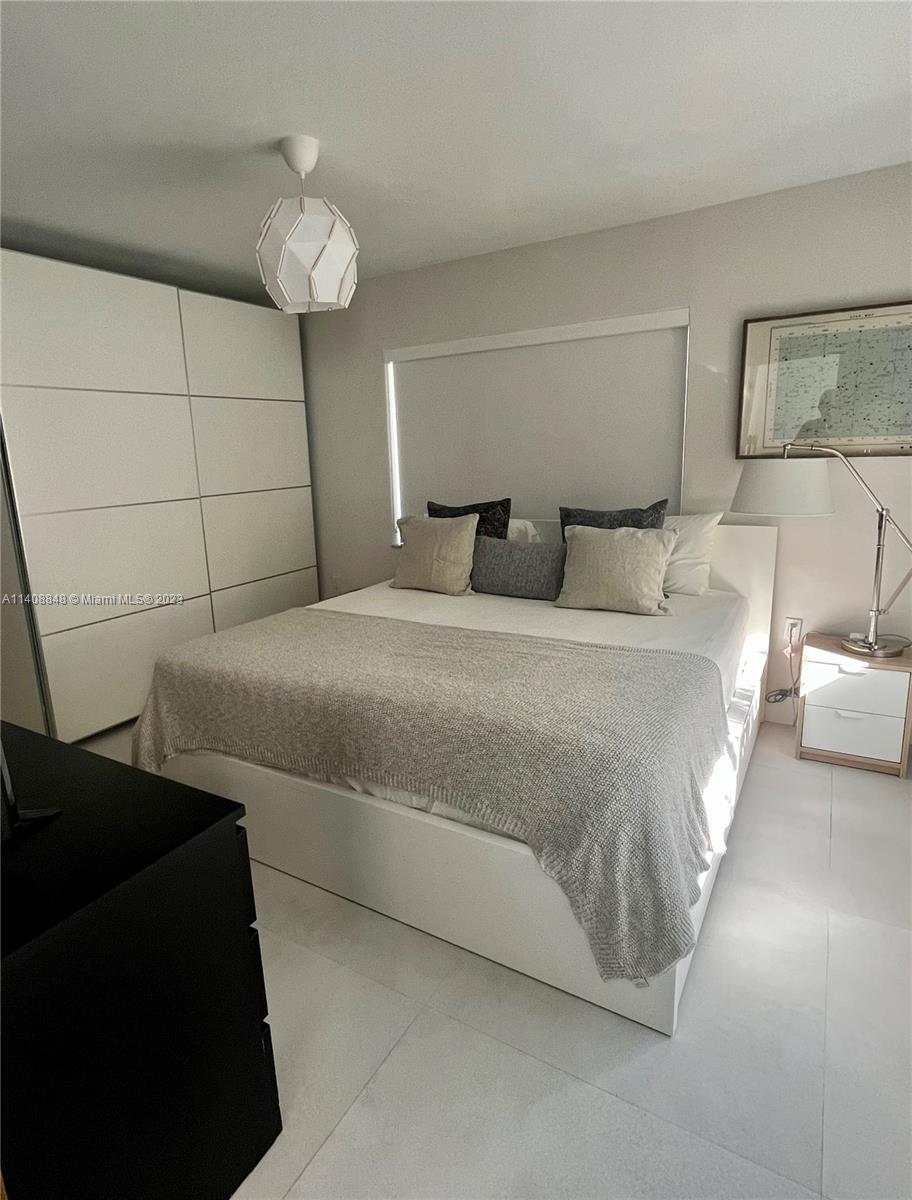 337 Southwest 23rd Road, Unit 1 Miami, FL 33129 - Photo 16 of 31 a bedroom with a bed and a chandelier